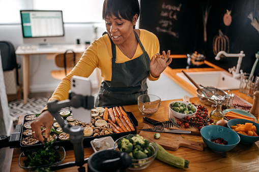 Woman making another video for his audience while cooking at domestic kitchen