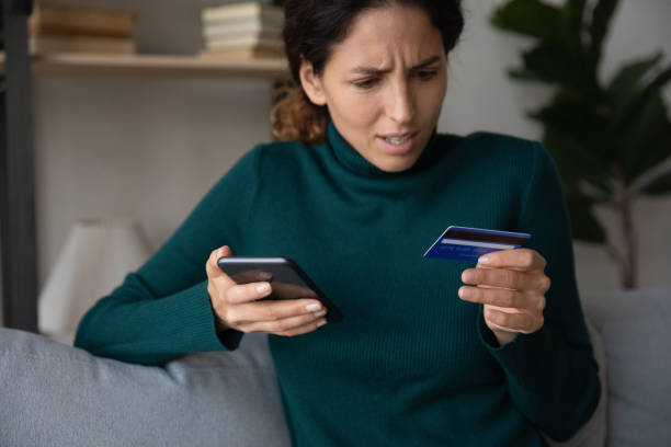 istock Shocked young latin lady using phone seeing bank card declined 1356201165