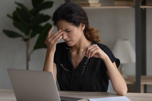 istock Tired latin woman office employee rub nose take spectacles off 1356201219