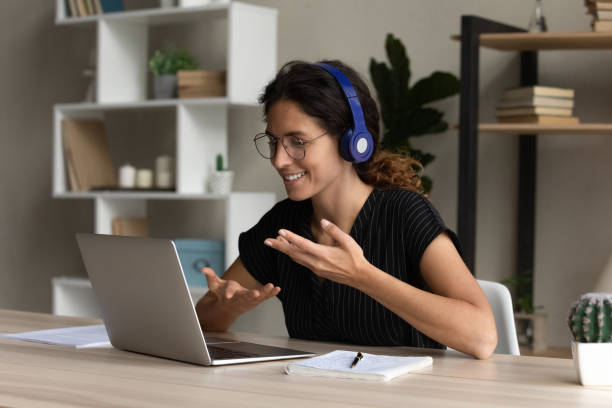 istock Hispanic female interpreter in headset working remotely talk use laptop 1356201221