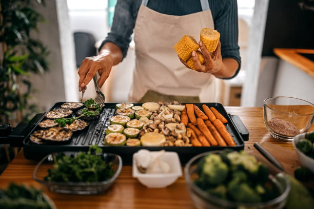 mujer recogiendo berenjenas a la parrilla de la barbacoa - roasted vegetable fotografías e imágenes de stock