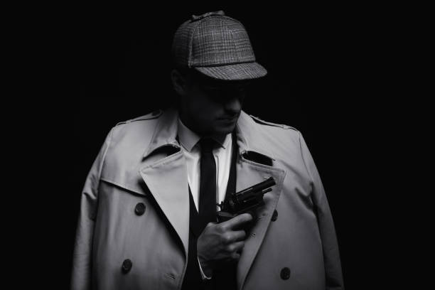 istock Old fashioned detective with revolver on dark background, black and white effect 1356202678