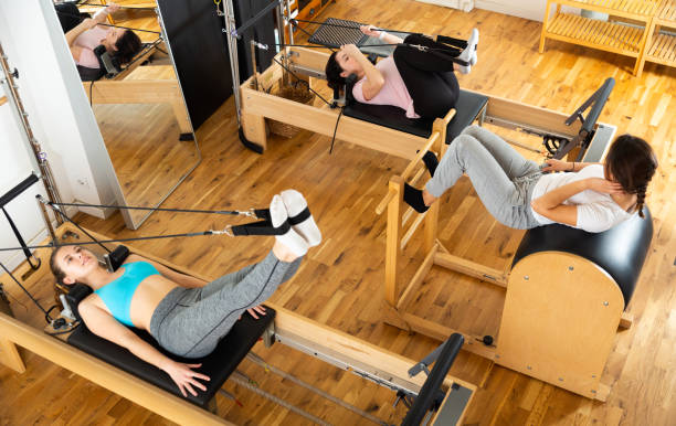 istock Pilates instructor training women at gym 1356202860
