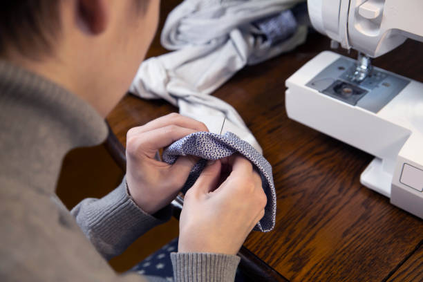 istock The girl sews while sitting at the sewing machine. Skill, hobby, profession. 1356203032