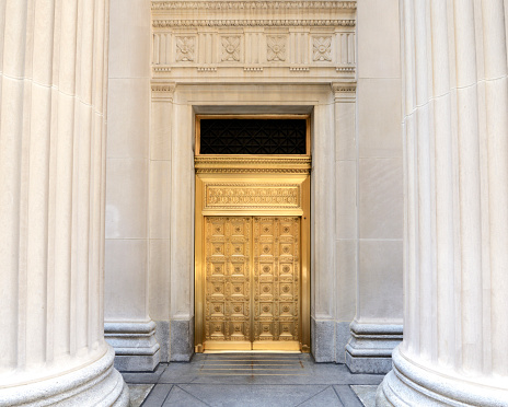 Golden door between architectural columns in a bank building, Chicago, Illinois.