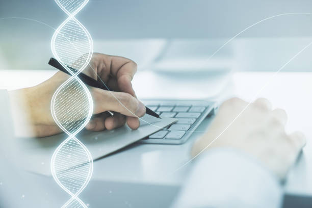 istock Creative DNA sketch and hand writing in notepad on background with laptop, biotechnology and genetic concept. Multiexposure 1356206631