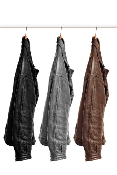 three leather jackets of different colors are hanging on a hanger. Isolated on white