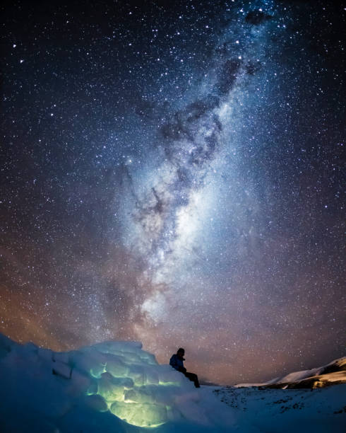 istock A person sitting on an igloo under the night sky. 1356212779