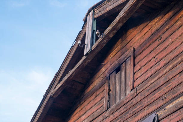 istock Old wooden building with blocked window and old-fashioned power supply. 1356214432