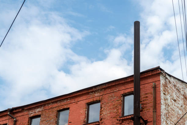 istock Old red brick building with black pipe and new windows. 1356214465