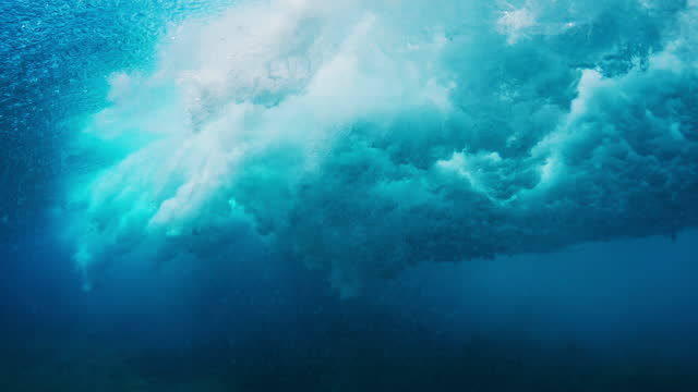 Wave rolls and breaks. Ocean wave rolls and breaks over the flat reef bottom in Maldives