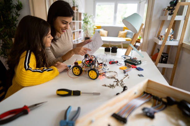 istock Mother, an engineer, helping her daughter to make a prototype of autonomous self-driven robotic car 1356215396