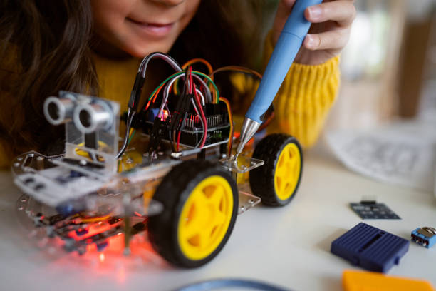 istock Unrecognizable schoolgirl, adjusting her prototype of an autonomous self-driven robotic car with screwdriver 1356215579