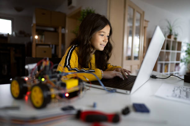 istock Schoolgirl, testing her robotic car with sensors via open-source hardware and software platform on her laptop 1356215665