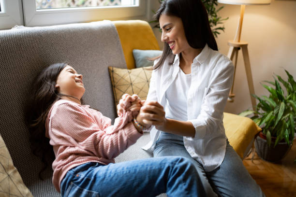 istock Charming mother and daughter playing on the sofa 1356217420
