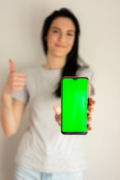 istock Green screen and mobile phone i female hand 1356217424