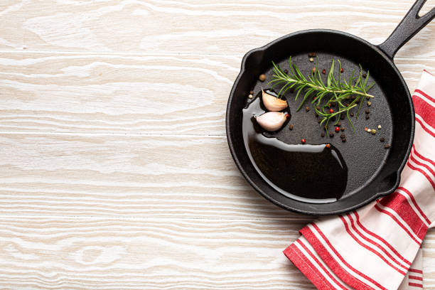 istock Cast iron frying pan with rosemary, garlic, pepper, oil copy space 1356217521