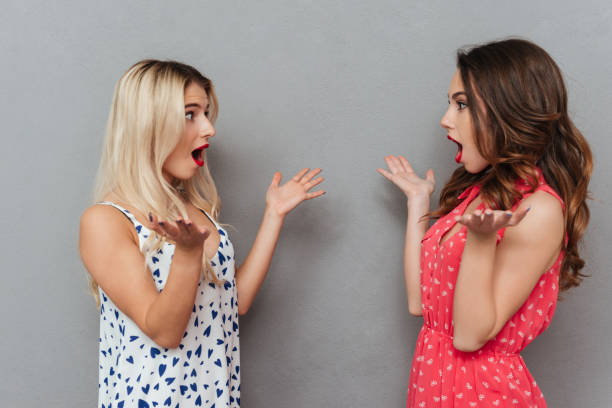 istock Pretty shocked young women looking at each other. 1356220175