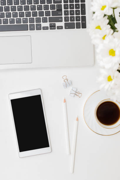 istock Flat lay mockup smartphone blank screen, laptop a cup of coffee on a white background 1356221402
