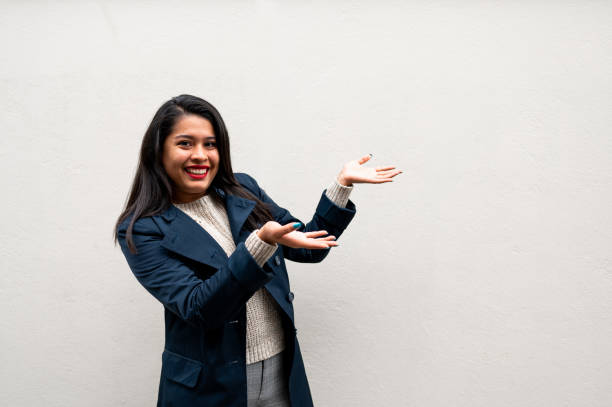 young smiling woman pointing her finger to empty copy space in isolated background. - boegbeeld model stockfoto's en -beelden