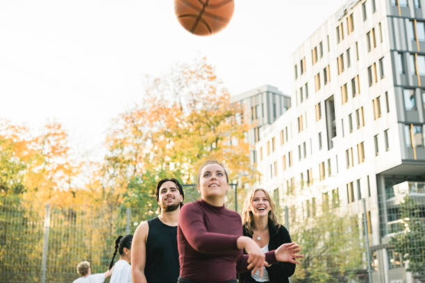 istock Young friends practicing free throws on outdoor court 1356221922