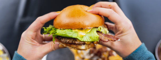 istock Horizontal banner or header Personal perspective gourmet bacon burger. 1356222454