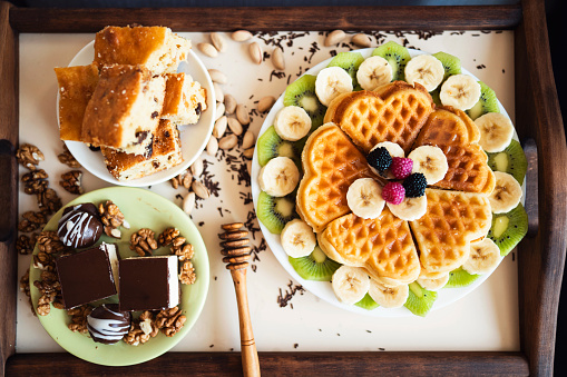 Plate with waffles, fruits and chocolate cakes