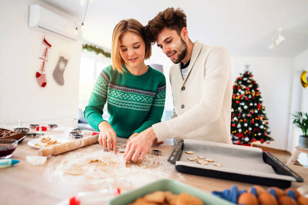istock Excited young couple making Christmas cookies, in their kitchen 1356222913