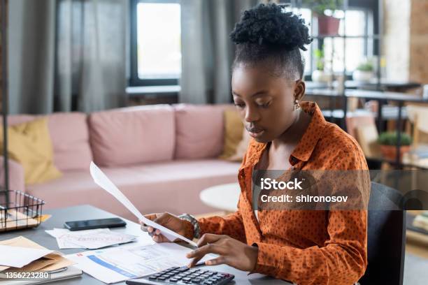 Blackwoman Calculating Tax Bill Stock Photo - Download Image Now - 20-24 Years, Adult, African Ethnicity