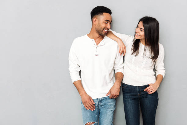 istock Happy young loving couple standing over grey wall 1356223956