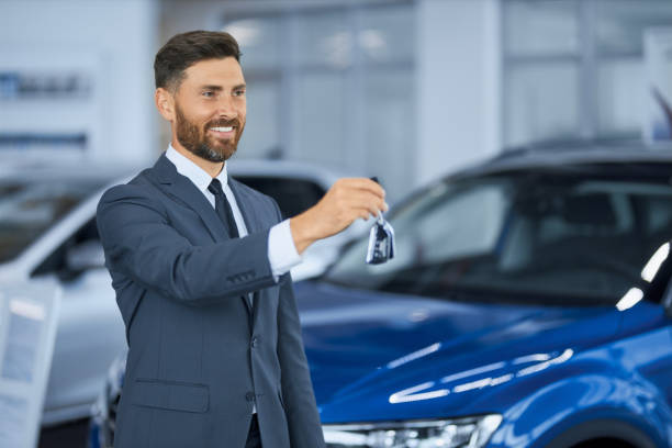 istock Happy man posing at modern car center with keys in hands 1356224074