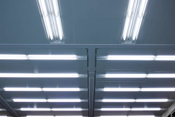 istock Ceiling with fluorescent lamps. Glowing structure of linear lighting fixtures. Abstract modern architecture background. 1356224575