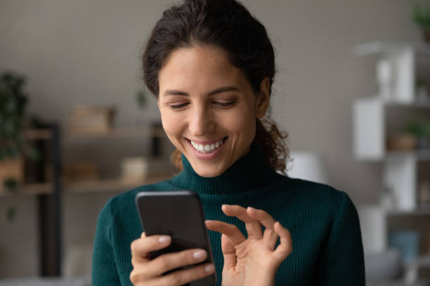 istock Smiling latina lady touch smartphone screen text answer on message 1356225327