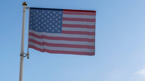 drapeau national des états-unis d’amérique sur un mât de drapeau devant un ciel bleu avec des rayons du soleil et une lentille éclairante. - diplomacy concepts and ideas usa washington dc photos et images de collection