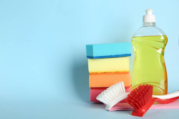 istock Cleaning product and tools on light blue background, space for text. Dish washing supplies 1356225586