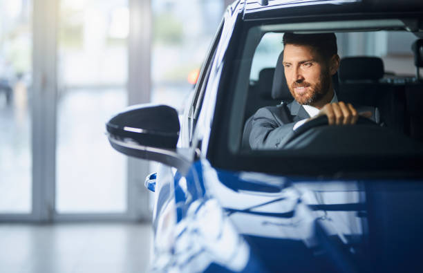 Businessman testing car at modern auto salon