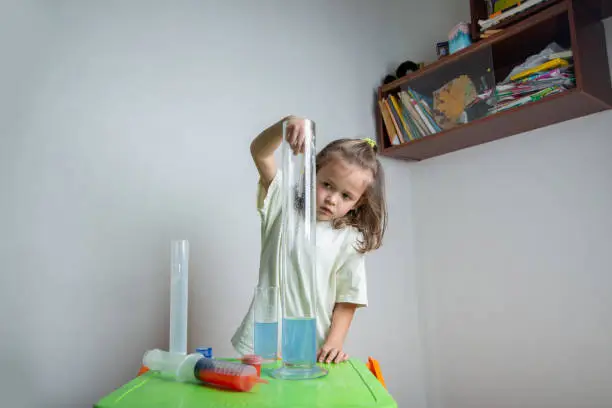 Photo of Child drips a colored liquid with a pipette into a test tube. A chemise experience at home. Homeschooling and distance education