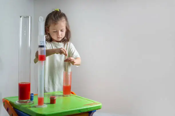 Photo of Child drips a colored liquid with a pipette into a test tube. A chemise experience at home. Homeschooling and distance education