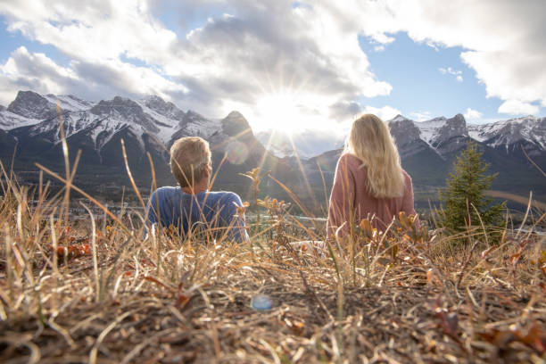 istock Hiking couple relax on grassy mountain ridge 1356227540