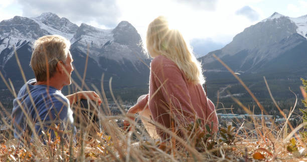 istock Hiking couple relax on grassy mountain ridge 1356227547