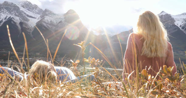 istock Hiking couple relax on grassy mountain ridge 1356227567