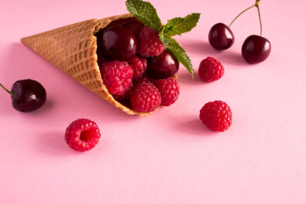 cornet de crème glacée à la framboise et cerise sur fond rose. gros plan. - raspberry ice cream close up fruit mint photos et images de collection