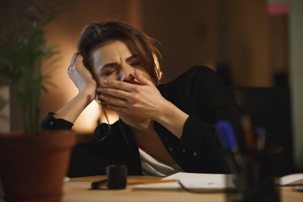 istock Woman yawning in office 1356228488