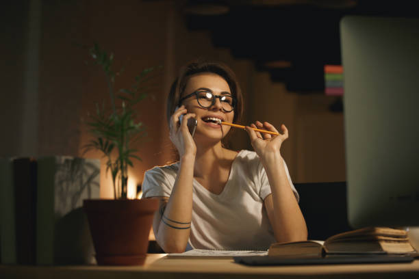 istock Young smiling woman designer talking by mobile phone 1356228497