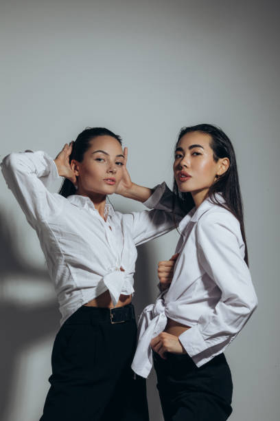 istock Two women with water drops on face pose in studio. 1356229965