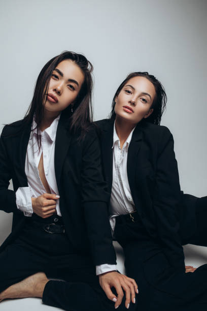 istock Two young women pose in studio sitting. 1356230054