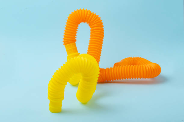 istock Creative composition from yellow and orange curved pop tubes.Modern atistress fidget. 1356232249