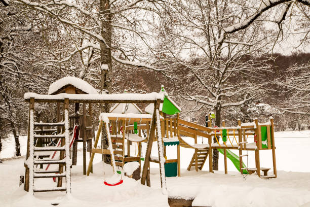 The playground in winter is covered with fresh snow.