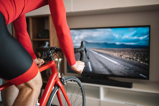 Man riding bike at home with interactive simulation trainor