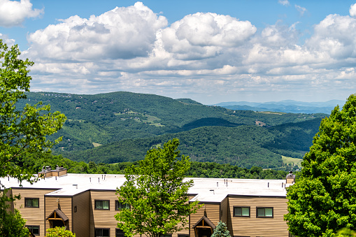 Sugar Mountain ski resort town with view of beautiful green mountains in summer in North Carolina with condo apartment buildings on peak in Blue Ridge Appalachia